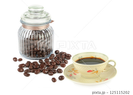 Chocolate dragees in a glass jar and Coffee in vintage porcelain cup isolated on white background. 125115202