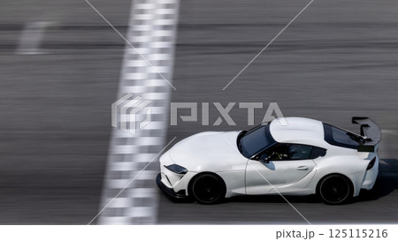Motion blurred super car crossing finish line checkered on race track circuit, Race super car blurred motion crossing finish checkered line on race track, concept win and goal reached. Motion blurred super car crossing finish line checkered on race track circuit, Race super car blurred motion crossing finish checkered line on race track, concept win and goal reached. 125115216