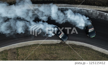 Top view two race car drift battle on race track with white smoke, Drift battle race car competition drift, Car drift battle on race track, Motorsport race car. Top view two race car drift battle on race track with white smoke, Drift battle race car competition drift, Car drift battle on race track, Motorsport race car. 125115412