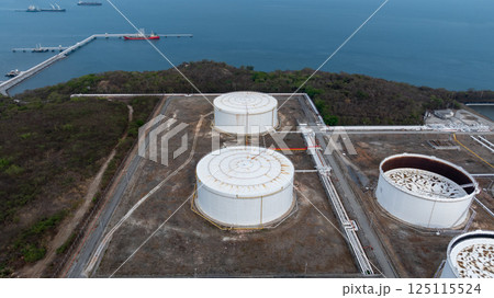 Oil terminal industrial facility storage tank, Oil storage tank with oil terminal port loading arm cargo oil product tanker ship, Global business oil and gas refinery industry commercial port. 125115524