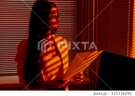 Business Woman Holding Documents in Golden Hour Office Light. Business Woman Holding Documents in Golden Hour Office Light. 125116295