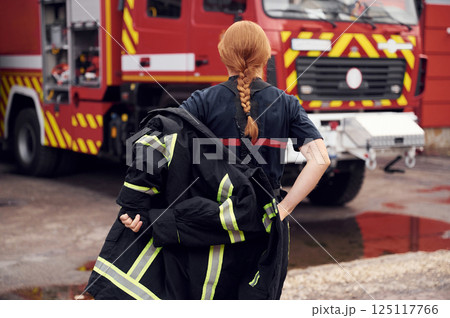 Rear view. Woman firefighter in uniform is at work in department Rear view. Woman firefighter in uniform is at work in department 125117766