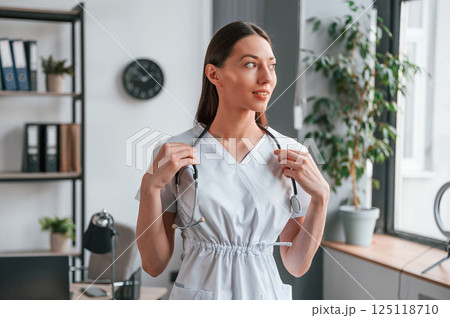 Portrait of young beautiful female doctor in white coat that is in the office Portrait of young beautiful female doctor in white coat that is in the office 125118710