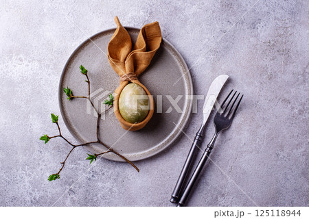Elegant Easter table setting with painted egg Elegant Easter table setting with painted egg 125118944