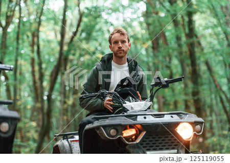 With safety helmet. TV driver is in the forest, having a ride at daytime With safety helmet. TV driver is in the forest, having a ride at daytime 125119055