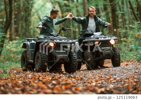 Making love gesture by hands. Beautiful couple. Two male atv riders is in the forest together Making love gesture by hands. Beautiful couple. Two male atv riders is in the forest together 125119063