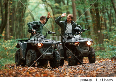 Two male atv riders is in the forest together 125119069