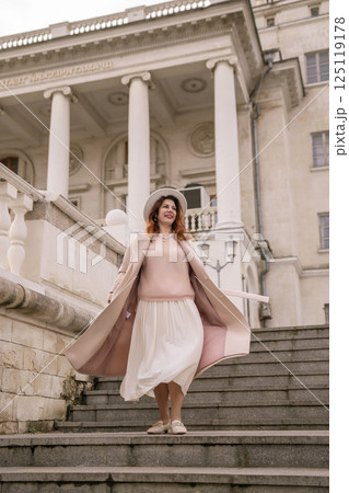 woman in elegant coat and hat against an intricate architectural backdrop, harmoniously blending modern fashion with historical allure. The soft daylight adds to its timeless appeal. woman in elegant coat and hat against an intricate architectural backdrop, harmoniously blending modern fashion with historical allure. The soft daylight adds to its timeless appeal. 125119178