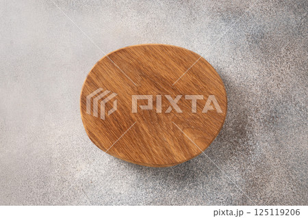 Wooden empty round cutting board on gray kitchen table top. Top view, flat lay. Cooking concept with copy space. Space for design. 125119206