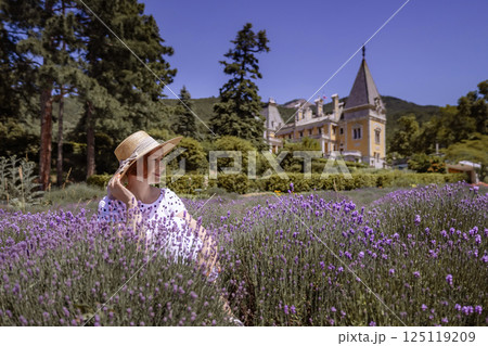 A woman is sitting in a field of purple flowers A woman is sitting in a field of purple flowers 125119209