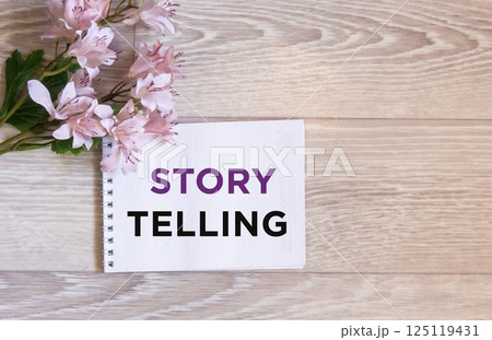 The text of the Storytelling written in a notebook on a wooden background 125119431