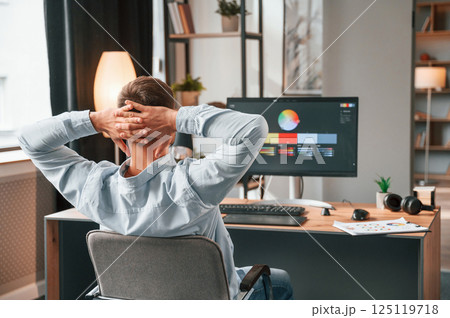Designer is sitting by the computer and using graphics tablet with stylus 125119718