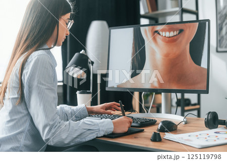 Portrait of woman. Young female retoucher working with computer and graphic tablet 125119798