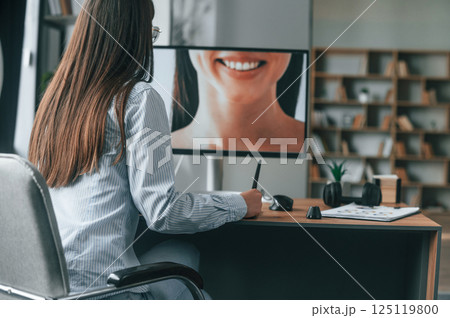Portrait of woman. Young female retoucher working with computer and graphic tablet Portrait of woman. Young female retoucher working with computer and graphic tablet 125119800