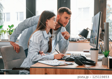 Using computer. Two young designers is working together in the office 125119853