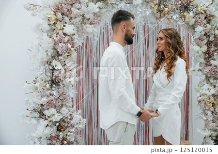 Holding by the hands. A young groom with his bride in a white dress. Wedding conception Holding by the hands. A young groom with his bride in a white dress. Wedding conception 125120015