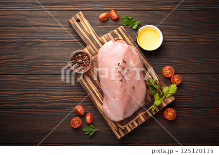 Raw healthy turkey fillet with herbs and spices on wooden cutting board top view, space for text Raw healthy turkey fillet with herbs and spices on wooden cutting board top view, space for text 125120115