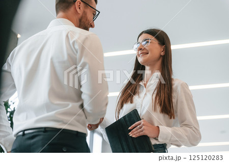 Talking, making a deal. Man and woman in formal clothes are working together indoors 125120283