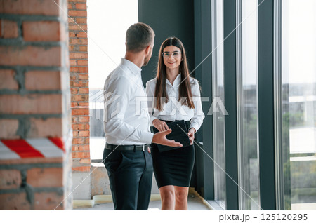Near big panoramic windows. Industry workers are in the building at daytime. Construction location Near big panoramic windows. Industry workers are in the building at daytime. Construction location 125120295