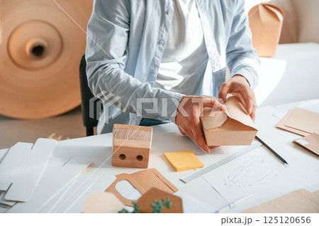 Process of making beautiful little wooden box. Print house worker in white clothes is indoors 125120656