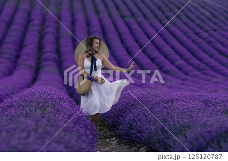 A woman is standing in a field of purple flowers 125120787