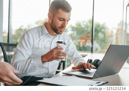 Using laptop. Man and woman are working in the modern office together Using laptop. Man and woman are working in the modern office together 125121214
