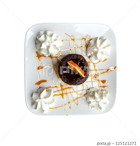 Fondant cake with liquid melting chocolate sauce and creamy decor on square white plate top view close-up, French traditional tasty dessert, isolated object soft selective focus, clipping path 125121271