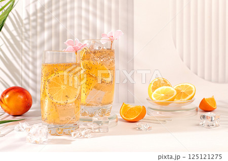 Modern still life with citrus fruits. Diet vegan cocktail with chia seeds, orange, lime, violet and ice. Detox diet and weight loss concept. Summer banner and screen template. 125121275