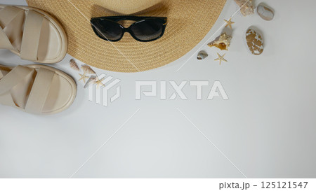 Summer travel vacation mood layout lifestyle spa or wellness concept with beach accessories and copy space. Top view flat lay background, including straw hat, sunglasses, sandals seashells and pebbles Summer travel vacation mood layout lifestyle spa or wellness concept with beach accessories and copy space. Top view flat lay background, including straw hat, sunglasses, sandals seashells and pebbles 125121547