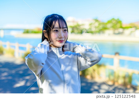 川沿いの街中をウォーキングするかっこいい女性　自分磨き　ダイエット　散歩　運動　 125122548