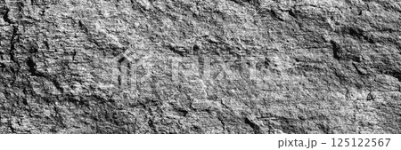 A close up of a rough, cracked rock surface with earthy gray. The natural texture and weathered details make it ideal for backgrounds, geology themes, and organic material references. 125122567
