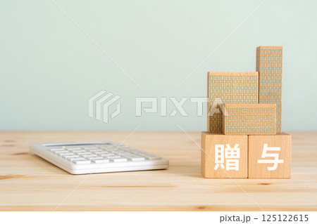 贈与と書かれたブロック、電卓、不動産の模型 125122615