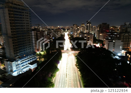 City lights illuminate skyline at night in urban area with busy traffic 125122934
