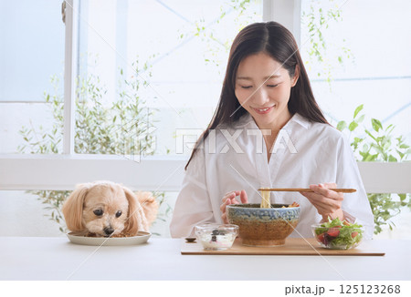 愛犬と一緒に食事を楽しむ女性 愛犬と一緒に食事を楽しむ女性 125123268