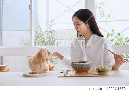 愛犬と一緒に食事を楽しむ女性 125123273