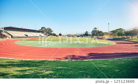 Sport, fitness and stadium track for running, outdoor and exercise landscape, blue sky and grass. Active, workout motivation and run for healthy life and sports view sun flare with cardio. Sport, fitness and stadium track for running, outdoor and exercise landscape, blue sky and grass. Active, workout motivation and run for healthy life and sports view sun flare with cardio. 125123600