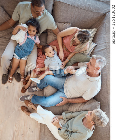 Family relax, generations and love in home with happy parents, grandparents and children on sofa bonding in overhead. Happy family, together and spending quality time with smile in living room. Family relax, generations and love in home with happy parents, grandparents and children on sofa bonding in overhead. Happy family, together and spending quality time with smile in living room. 125123602