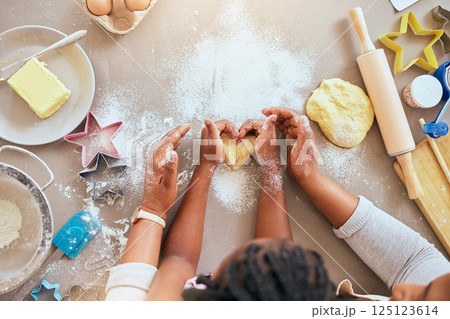 Black woman, child hands or kitchen baking of heart shape pastry, house cookies or dessert biscuit scone in family home. Top view, mother or girl cooking food in help, support or learning cake recipe Black woman, child hands or kitchen baking of heart shape pastry, house cookies or dessert biscuit scone in family home. Top view, mother or girl cooking food in help, support or learning cake recipe 125123614