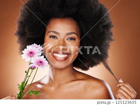 Flower, beauty and hair care of a black woman portrait with skin glow and wellness. Woman model with afro happy about natural, luxury and cosmetic beauty with a smile and flowers for facial treatment 125123635