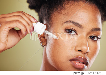 Black woman, facial essential oil and serum for dermatology, natural beauty and aesthetic makeup on studio background. Portrait model face, skincare and liquid cosmetics, retinol and hyaluronic acid 125123755