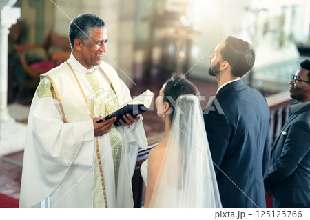 Wedding, couple and priest with a bible in church praying to God with a Christian pastor reading the holy book. Love, bride and groom say an oath for a faithful and spiritual marriage commitment Wedding, couple and priest with a bible in church praying to God with a Christian pastor reading the holy book. Love, bride and groom say an oath for a faithful and spiritual marriage commitment 125123766