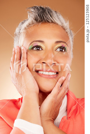 Elderly model, eye makeup and beauty for fashion, cosmetics and skin wellness with smile by brown wall. Cosmetic face, senior woman and happy with skincare, aesthetic and style by studio background Elderly model, eye makeup and beauty for fashion, cosmetics and skin wellness with smile by brown wall. Cosmetic face, senior woman and happy with skincare, aesthetic and style by studio background 125123908