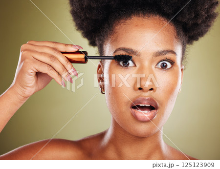 Black woman, surprise eyes and cosmetics mascara or makeup, natural beauty and skincare glow in studio. African girl model, facial cosmetology wellness and eyelash product care with shocked face 125123909
