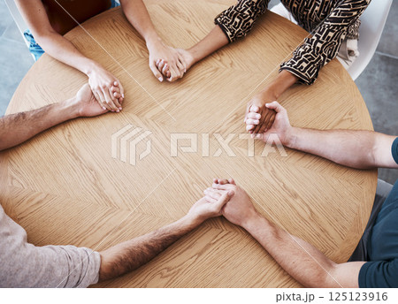 Business people holding hands in therapy group, team building or staff support with diversity, empathy and solidarity. Corporate circle hand holding on table above for prayer, trust and community Business people holding hands in therapy group, team building or staff support with diversity, empathy and solidarity. Corporate circle hand holding on table above for prayer, trust and community 125123916