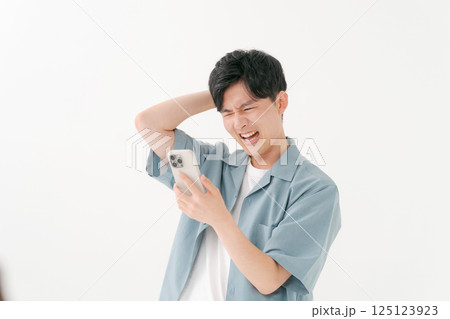 スマホを操作する若い男性 スマホを操作する若い男性 125123923