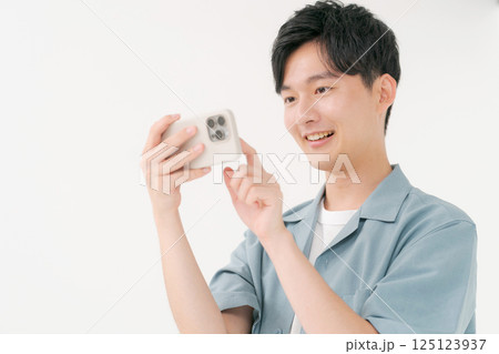 スマホを操作する若い男性 125123937
