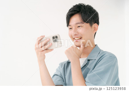 スマホを操作する若い男性 125123938