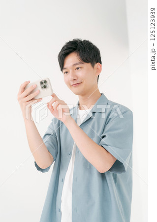 スマホを操作する若い男性 125123939