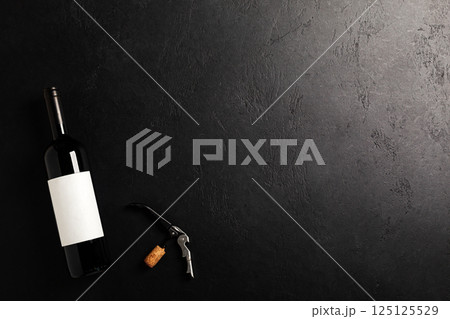 Bottle with red wine on black. Flat lay Bottle with red wine on black. Flat lay 125125529