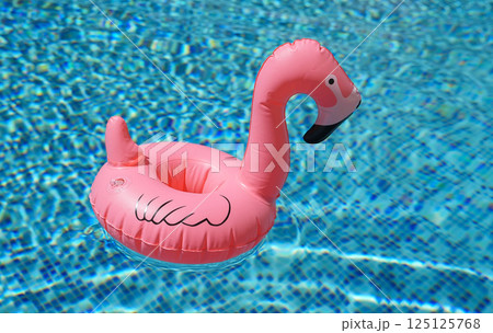 Inflatable toy of pink flamingo in swimming pool Inflatable toy of pink flamingo in swimming pool 125125768